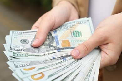 Photo of Woman counting her money outdoors, closeup view