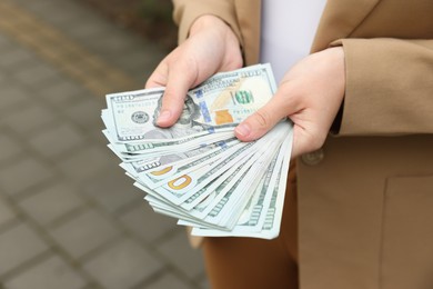 Photo of Woman counting her money outdoors, closeup view
