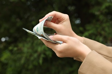 Photo of Woman counting her money outdoors, closeup view