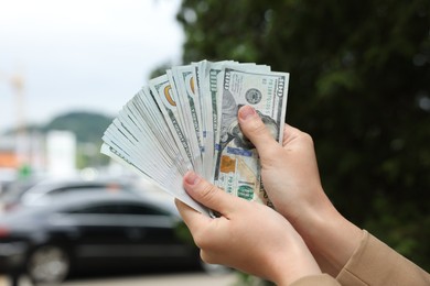Photo of Woman counting her money outdoors, closeup view