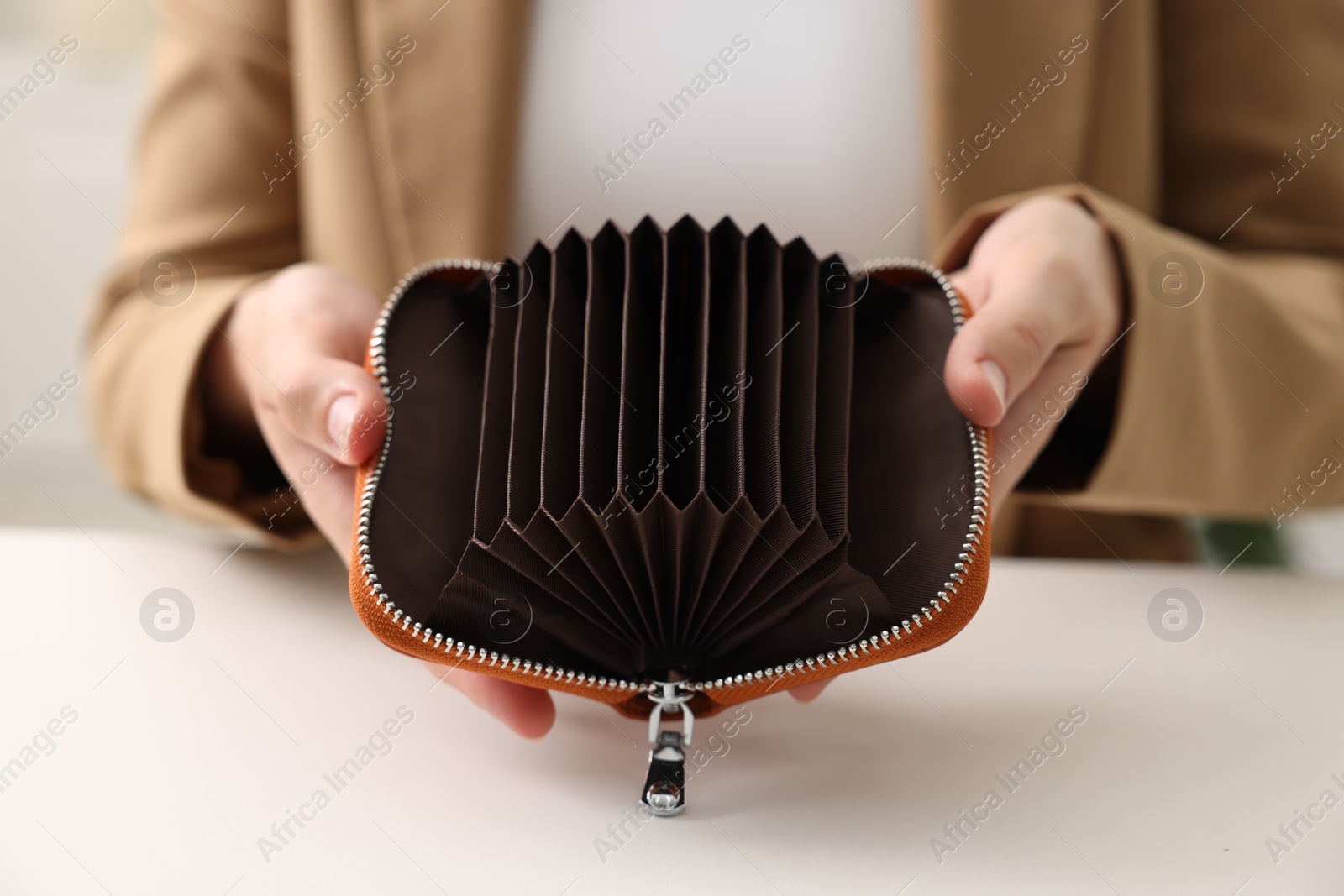 Woman with empty wallet at white table, closeup Photo of Woman with empty wallet at white table, closeup
