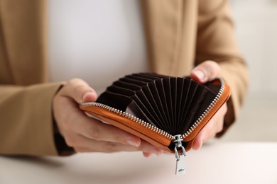 Photo of Woman with empty wallet at white table, closeup