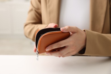 Photo of Woman with empty wallet at white table, closeup