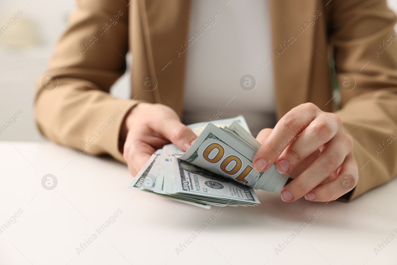 Woman counting money at white table, closeup Photo of Woman counting money at white table, closeup