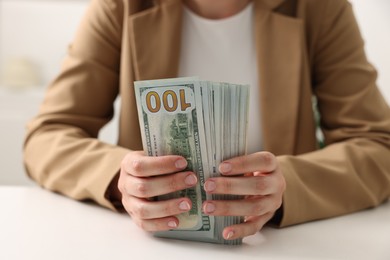 Photo of Woman counting money at white table, closeup