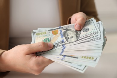 Photo of Woman counting money at white table, closeup