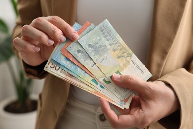 Photo of Woman counting her money indoors, closeup view