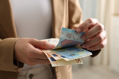 Photo of Woman counting her money indoors, closeup view
