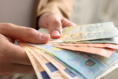 Photo of Woman counting her money indoors, closeup view
