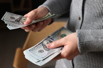 Photo of Woman counting her money indoors, closeup view