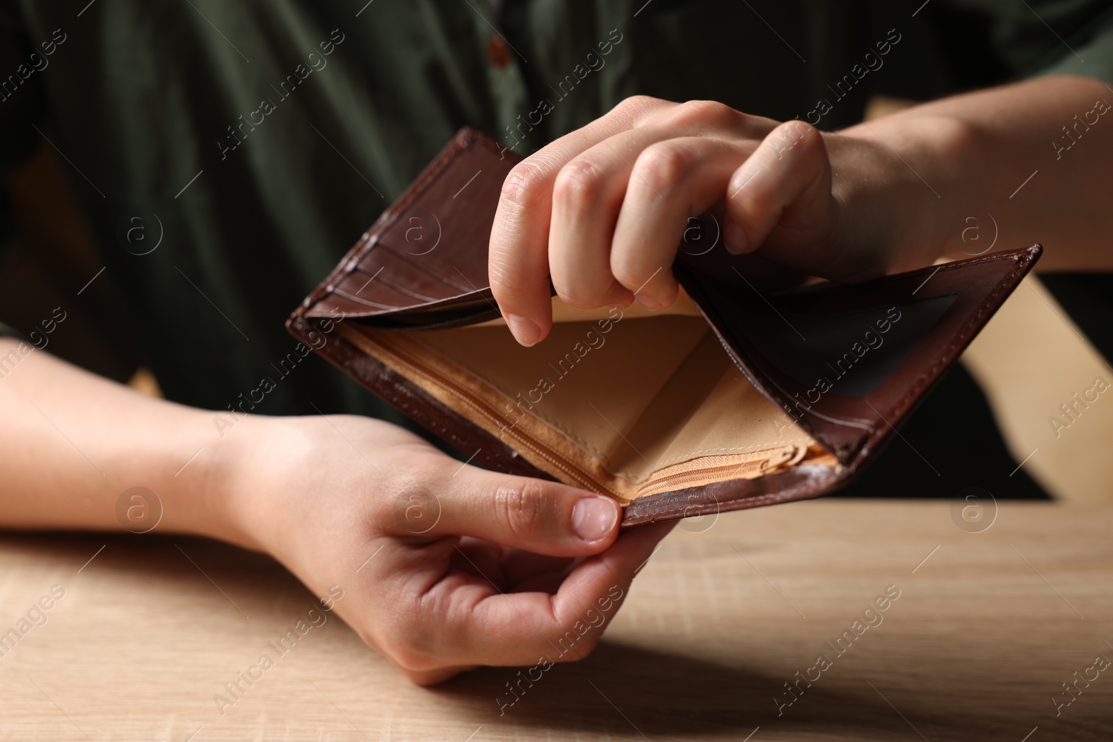Woman with empty wallet at wooden table, closeup Photo of Woman with empty wallet at wooden table, closeup