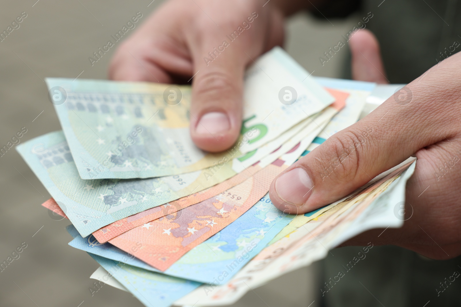 Photo of Man counting his money outdoors, closeup view