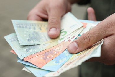 Photo of Man counting his money outdoors, closeup view