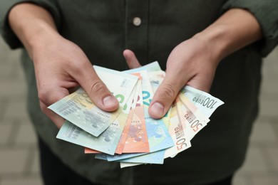 Photo of Man counting his money outdoors, closeup view