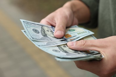 Photo of Man counting his money outdoors, closeup view