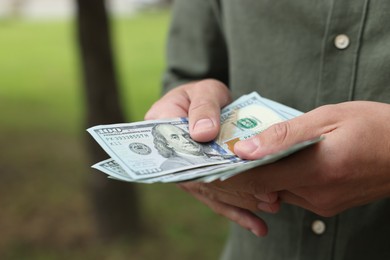 Photo of Man counting his money outdoors, closeup view