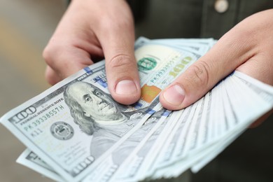 Photo of Man counting his money outdoors, closeup view