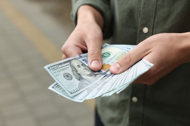 Photo of Man counting his money outdoors, closeup view