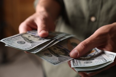 Photo of Man counting his money indoors, closeup view