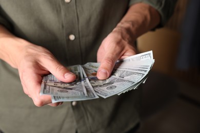 Photo of Man counting his money indoors, closeup view