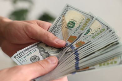 Photo of Man counting his money indoors, closeup view