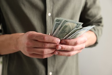 Photo of Man counting his money indoors, closeup view