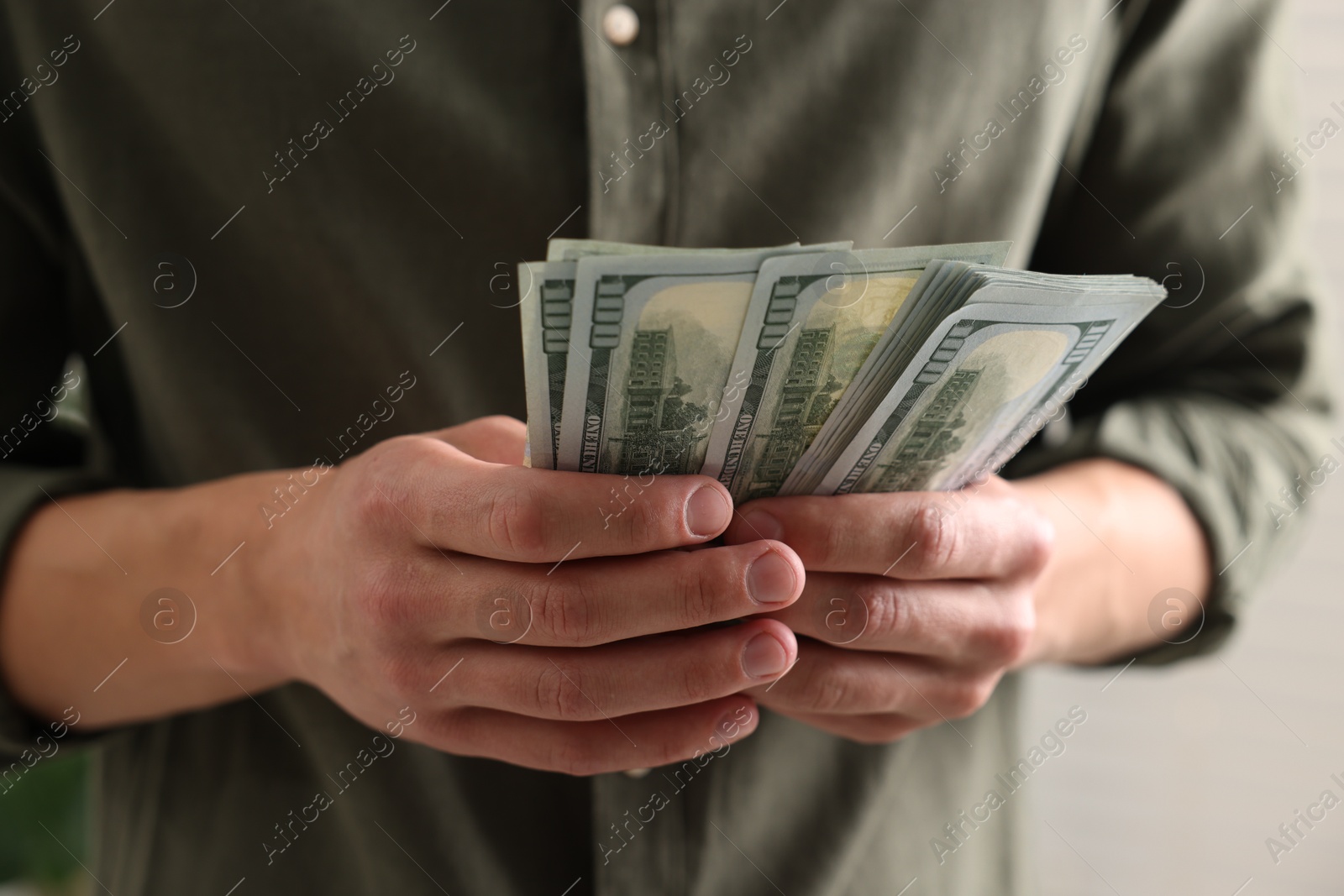 Photo of Man counting his money indoors, closeup view