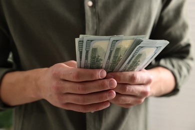 Photo of Man counting his money indoors, closeup view