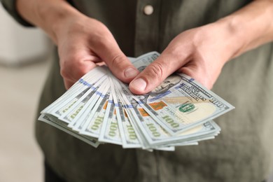 Photo of Man counting his money indoors, closeup view