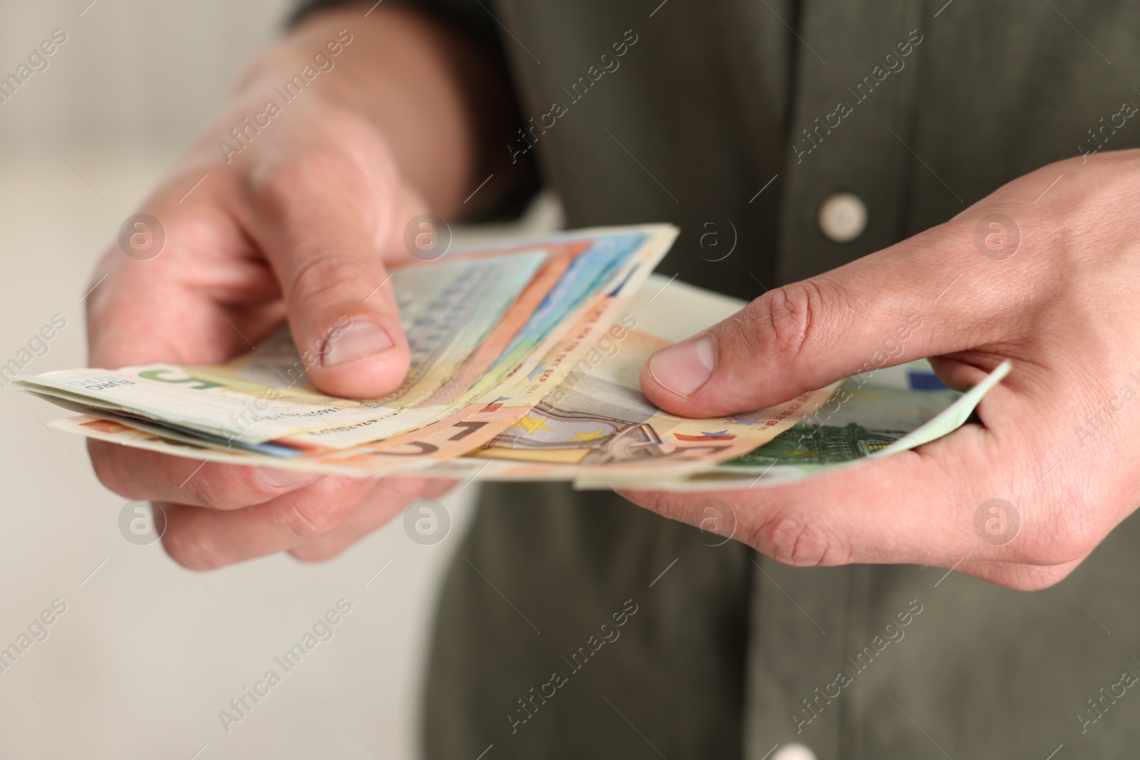 Man counting his money indoors, closeup view Photo of Man counting his money indoors, closeup view