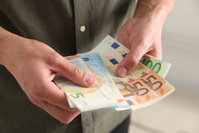 Photo of Man counting his money indoors, closeup view