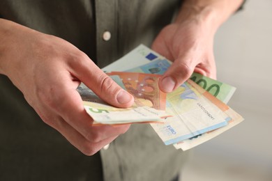 Photo of Man counting his money indoors, closeup view