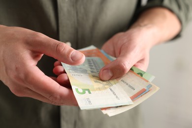 Photo of Man counting his money indoors, closeup view