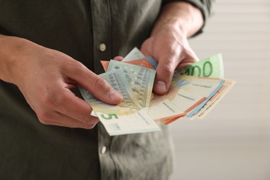 Photo of Man counting his money indoors, closeup view