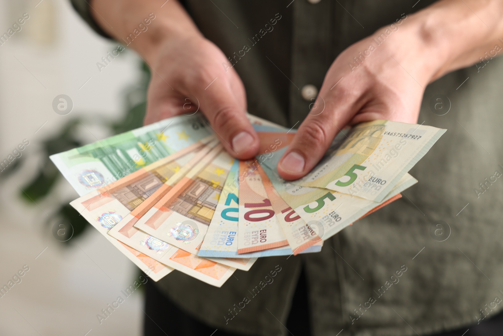 Man counting his money indoors, closeup view Photo of Man counting his money indoors, closeup view