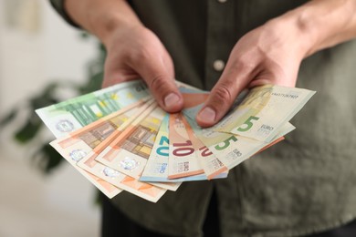 Photo of Man counting his money indoors, closeup view
