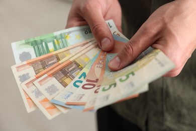 Photo of Man counting his money indoors, closeup view