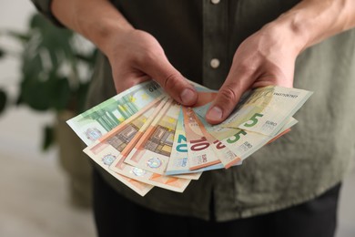 Photo of Man counting his money indoors, closeup view