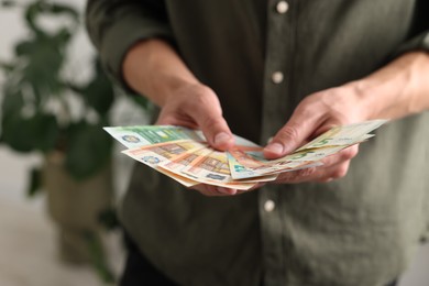Photo of Man counting his money indoors, closeup view