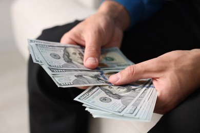 Photo of Man counting his money indoors, closeup view