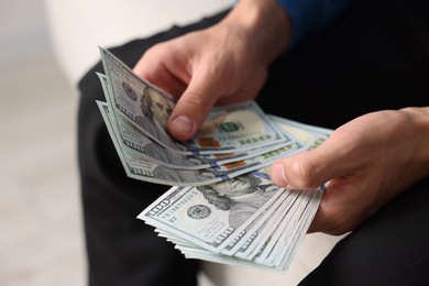 Photo of Man counting his money indoors, closeup view