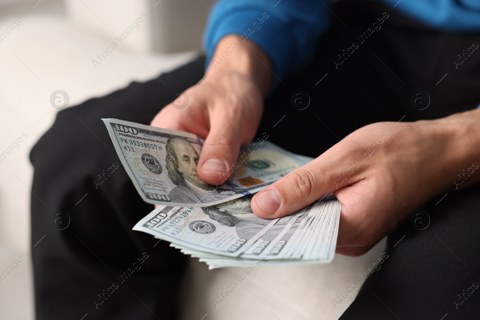 Man counting his money indoors, closeup view Photo of Man counting his money indoors, closeup view