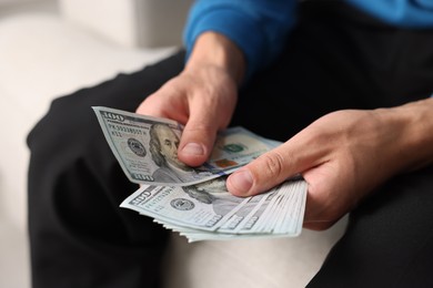 Photo of Man counting his money indoors, closeup view