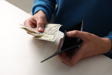 Photo of Man counting money at white table, closeup