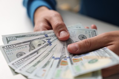 Photo of Man counting money at white table, closeup