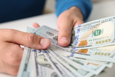 Photo of Man counting money at white table, closeup