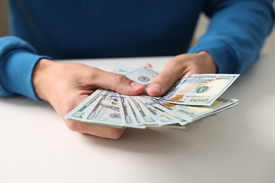 Photo of Man counting money at white table, closeup