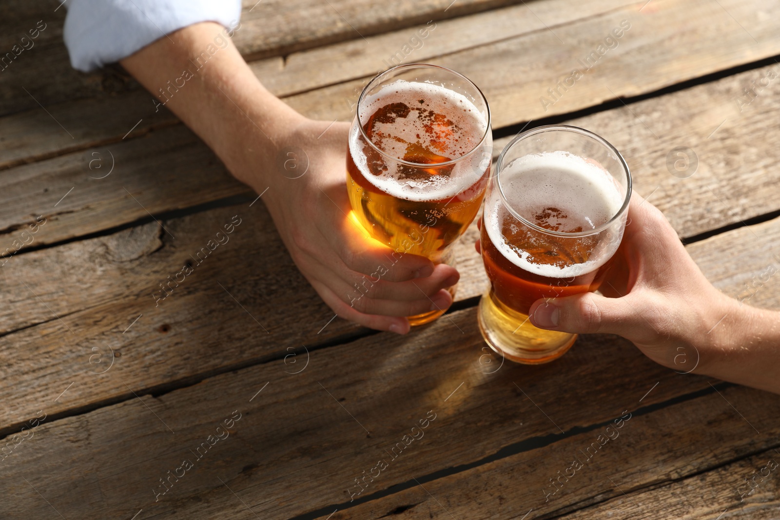 Photo of Friends with glasses of beer at wooden table, above view
