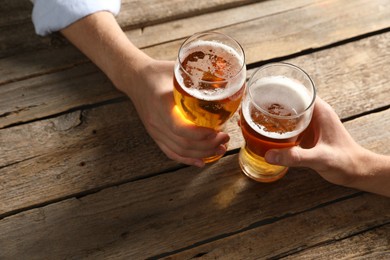 Photo of Friends with glasses of beer at wooden table, above view