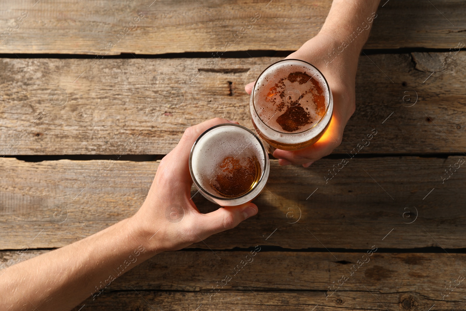 Photo of Friends with glasses of beer at wooden table, top view